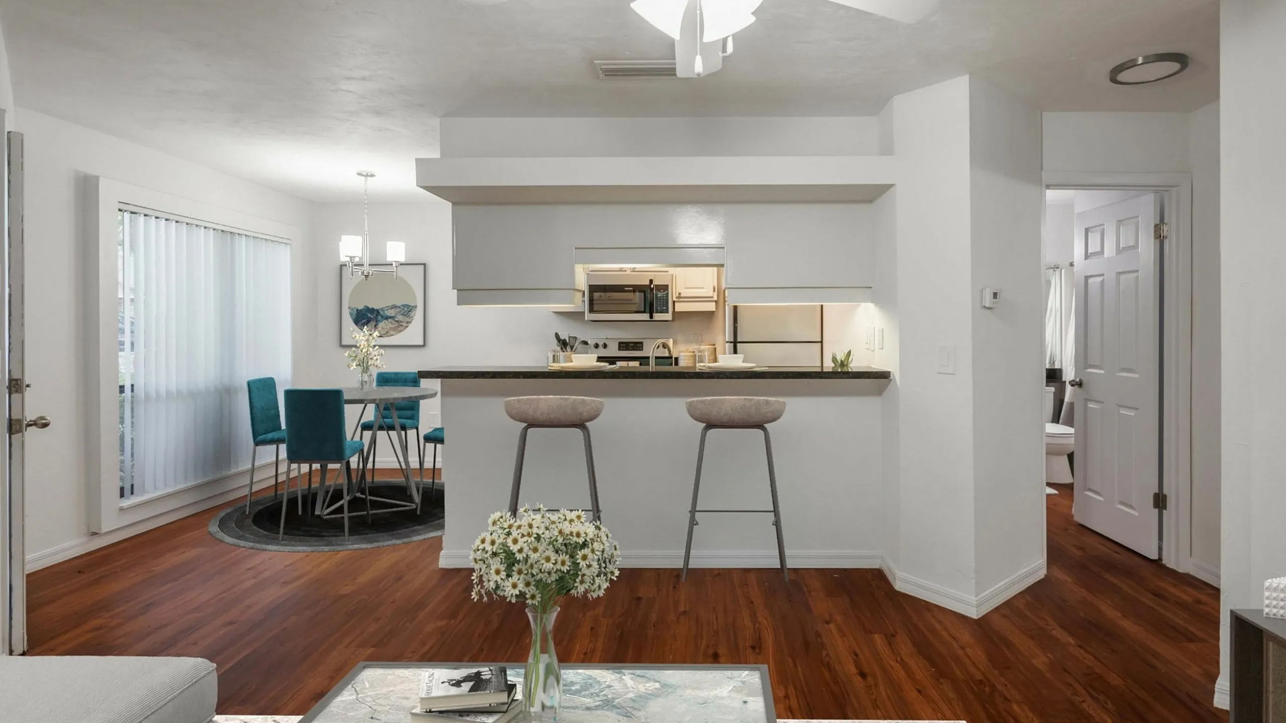 Chic open-concept living space featuring a modern kitchen with breakfast bar, elegant dining area, and cozy seating with vibrant teal accents.