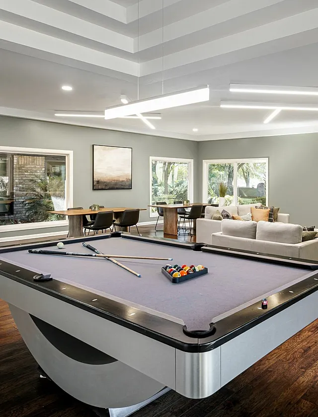 Modern apartment lounge with sleek pool table, plush seating, and ambient lighting at The Laurels Apartments.