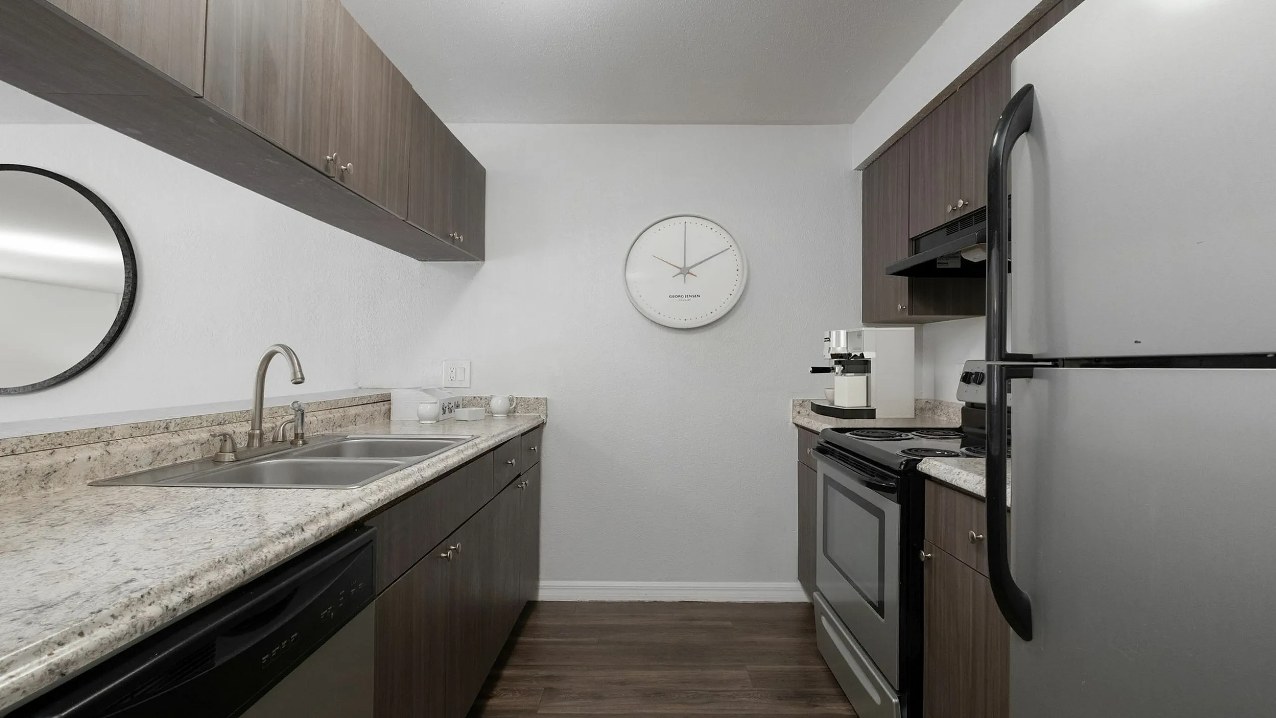 Modern kitchen design with sleek dark wood cabinets, stainless steel appliances, and elegant granite countertops.