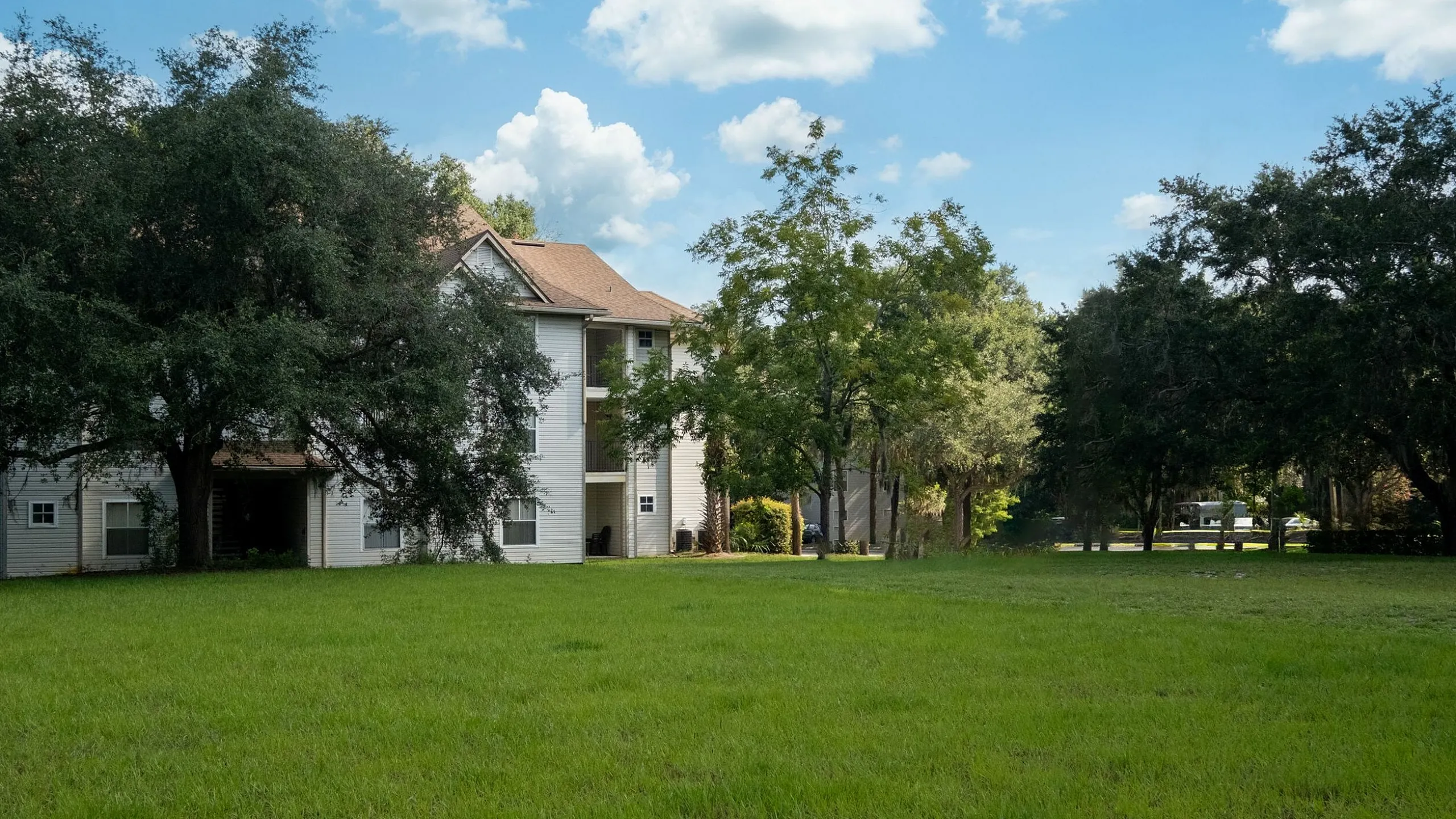 Charming apartment complex nestled amidst lush greenery and spacious lawns, perfect for tranquil living.