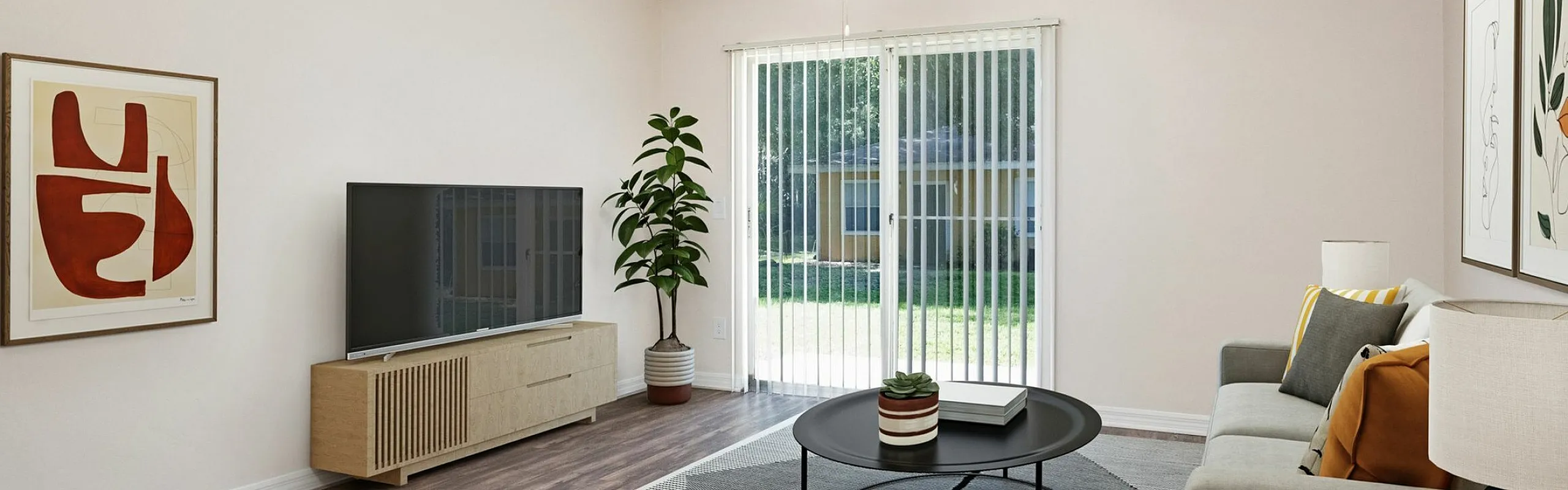 Inviting living room with contemporary decor, featuring a stylish grey sofa, a sleek round coffee table, artful wall prints, and large sliding glass doors opening to a lush garden view.