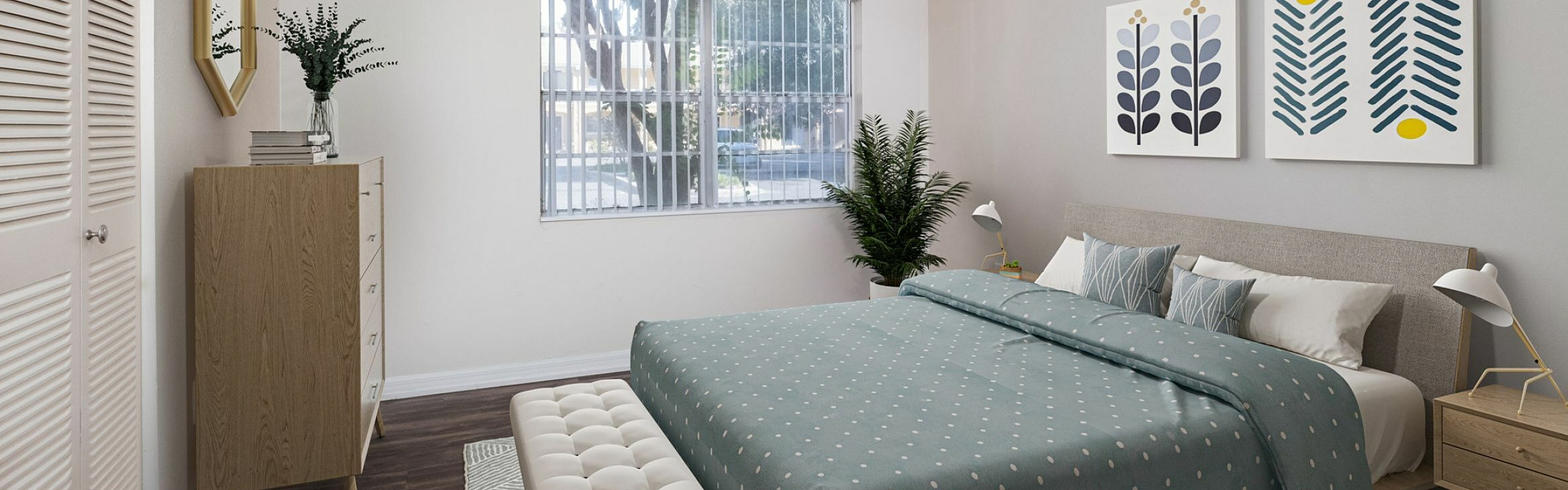Inviting bedroom featuring a cozy bed with polka dot bedding, stylish artwork, and a large window offering natural light.