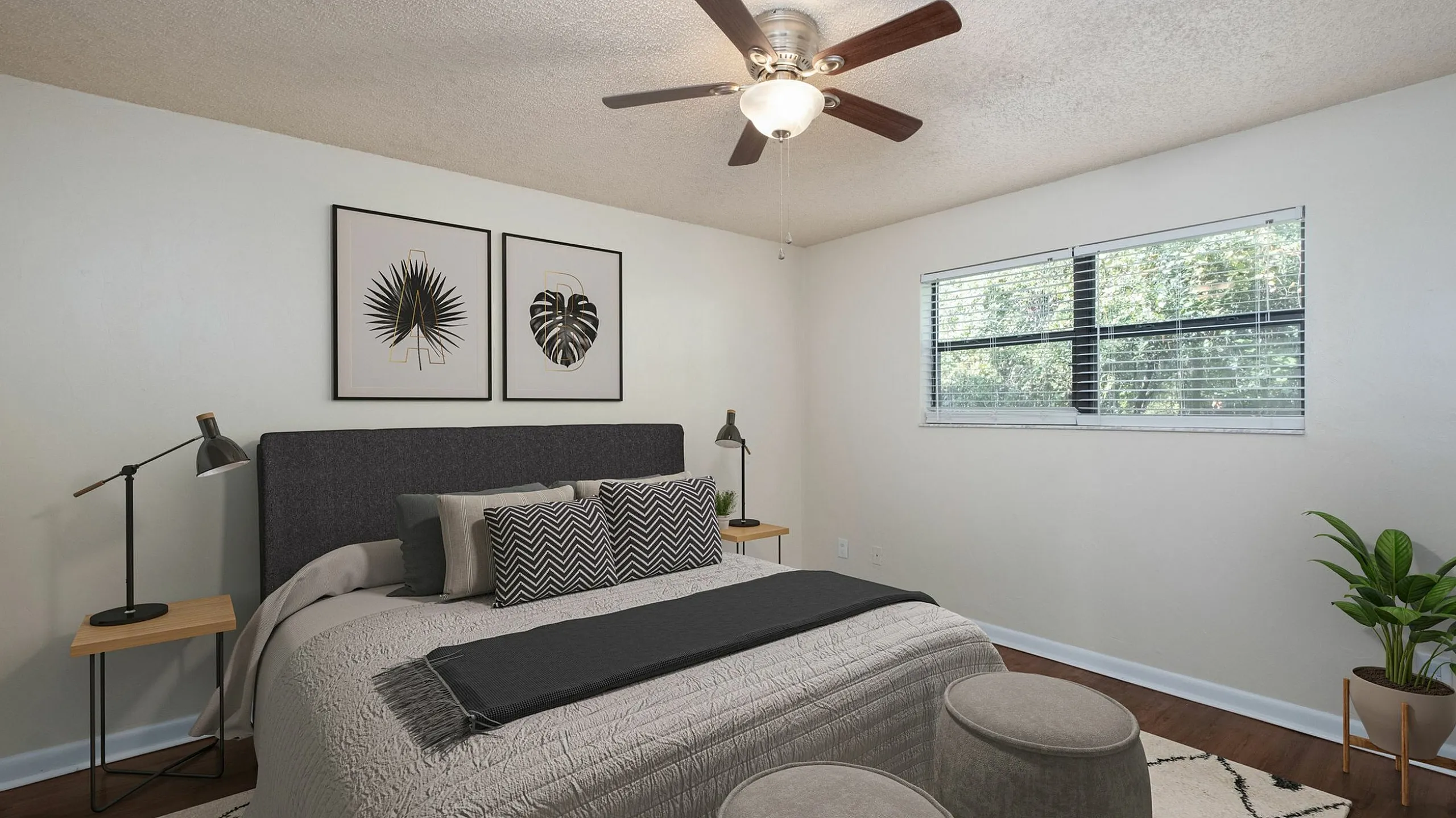 Inviting bedroom with contemporary decor featuring a cozy bed, elegant wall art, and a large window for natural light.