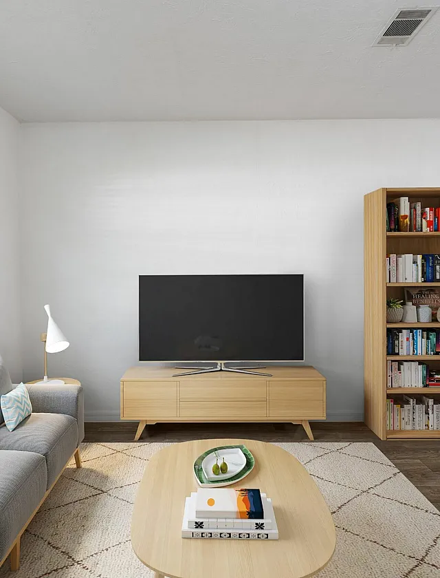 Bright and inviting living room with a modern gray sofa, elegant bookshelf, and a sleek TV unit set against a large window with natural light.