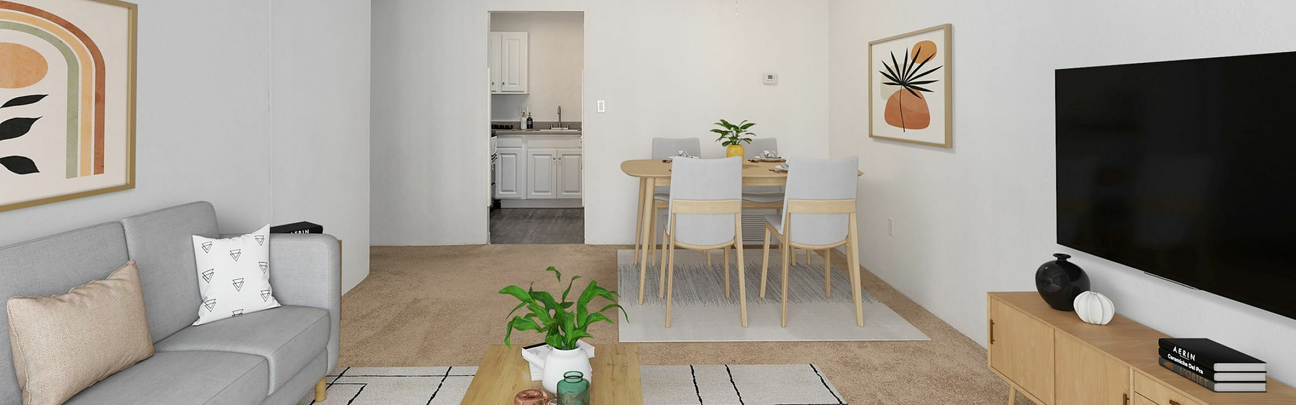 Cozy living room with modern gray sofa, chic wall art, and sleek coffee table, leading to a dining area and kitchen, ideal for stylish urban living.