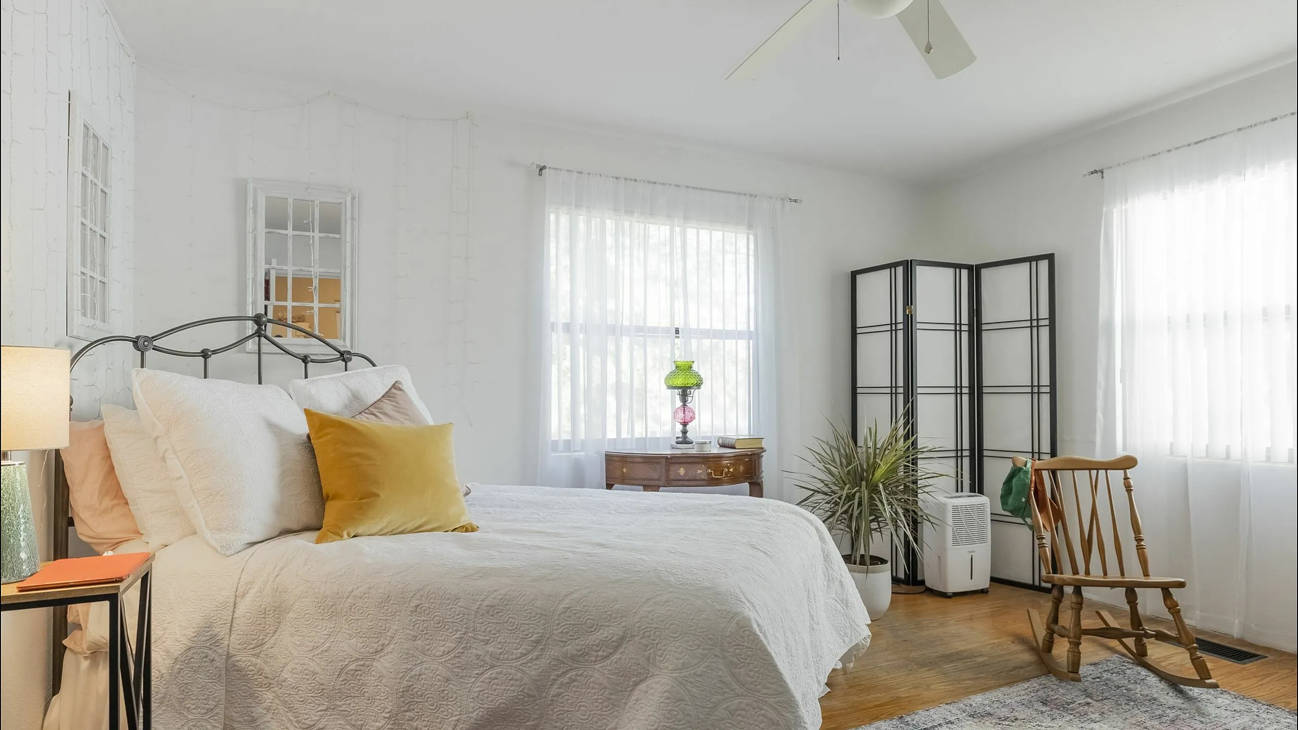 Bright, inviting bedroom with elegant decor, featuring a cozy bed, vintage furniture, and charming natural light.
