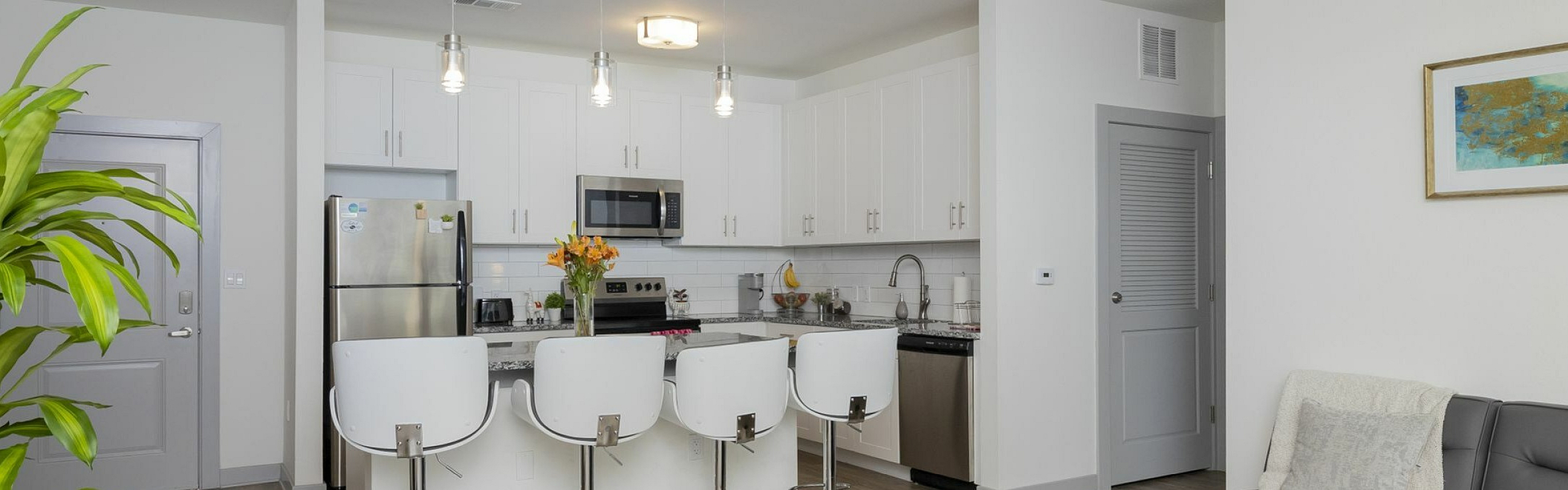Modern open-concept living space with sleek kitchen, cozy lounge area, and stylish bar seating, ideal for entertaining and relaxation.