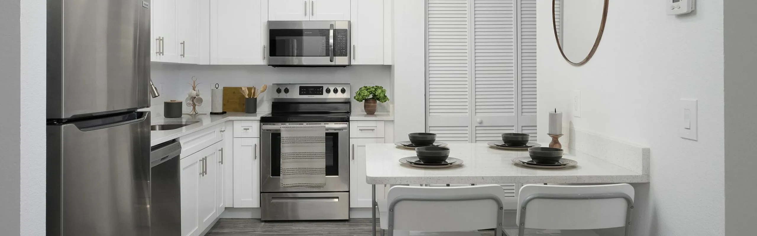 Modern kitchen with sleek stainless steel appliances, elegant white cabinetry, and a cozy breakfast bar with stylish seating.