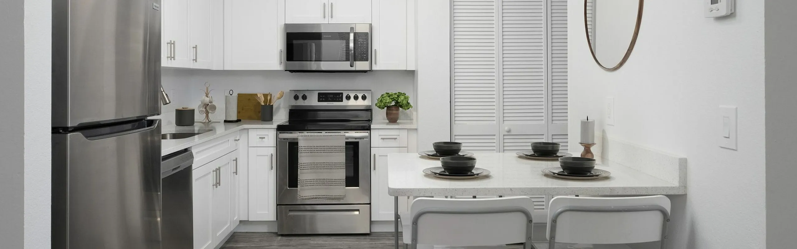 Modern kitchen with sleek stainless steel appliances, elegant white cabinetry, and a cozy breakfast bar with stylish seating.