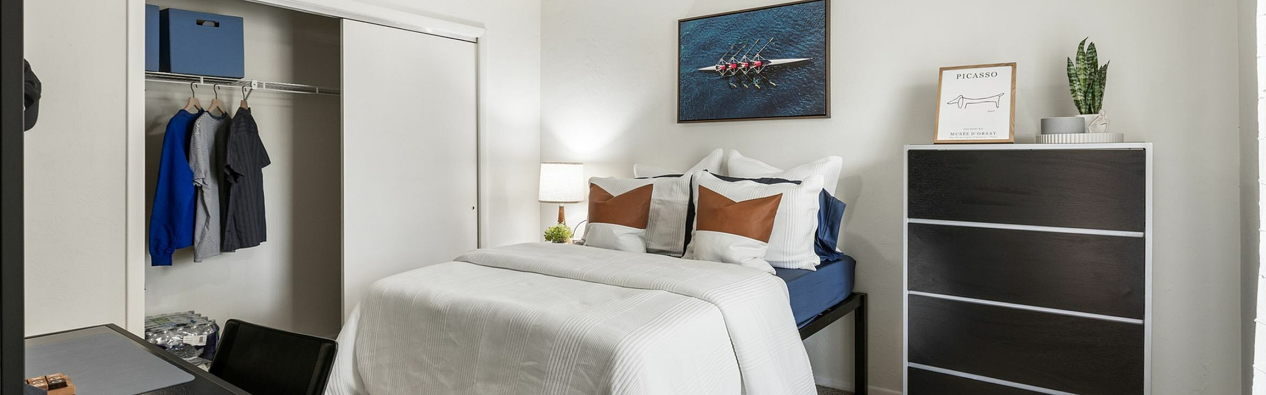 Cozy bedroom with a sleek modern design, featuring a comfortable double bed, stylish dresser, and open closet.