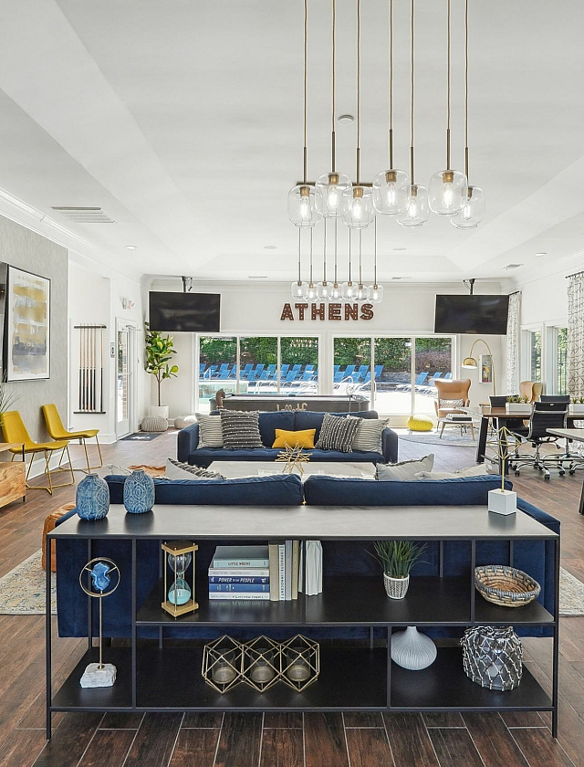 Contemporary open-concept lounge area with elegant lighting, stylish seating, and expansive windows offering a scenic outdoor view.