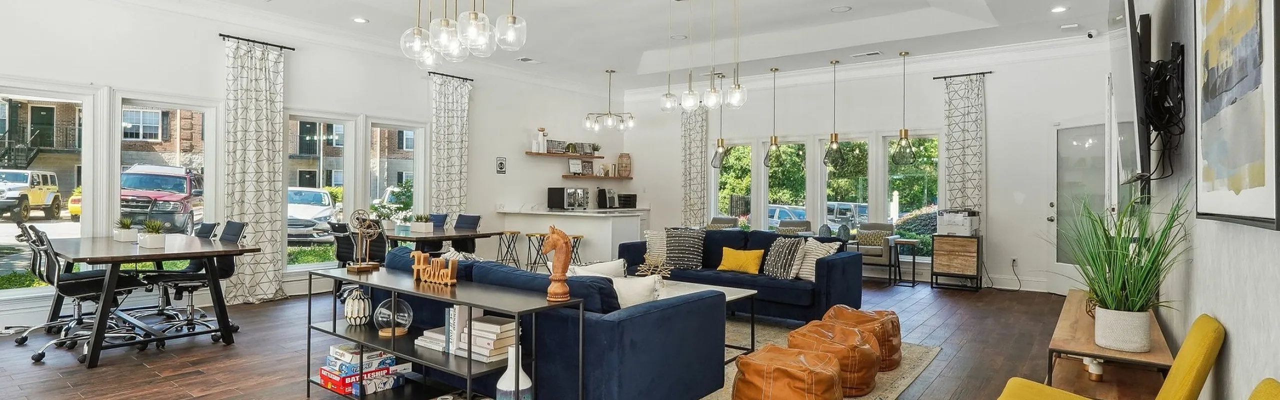 Chic and spacious modern living area with elegant lighting, stylish blue seating, and warm wood flooring, perfect for entertaining and relaxation.