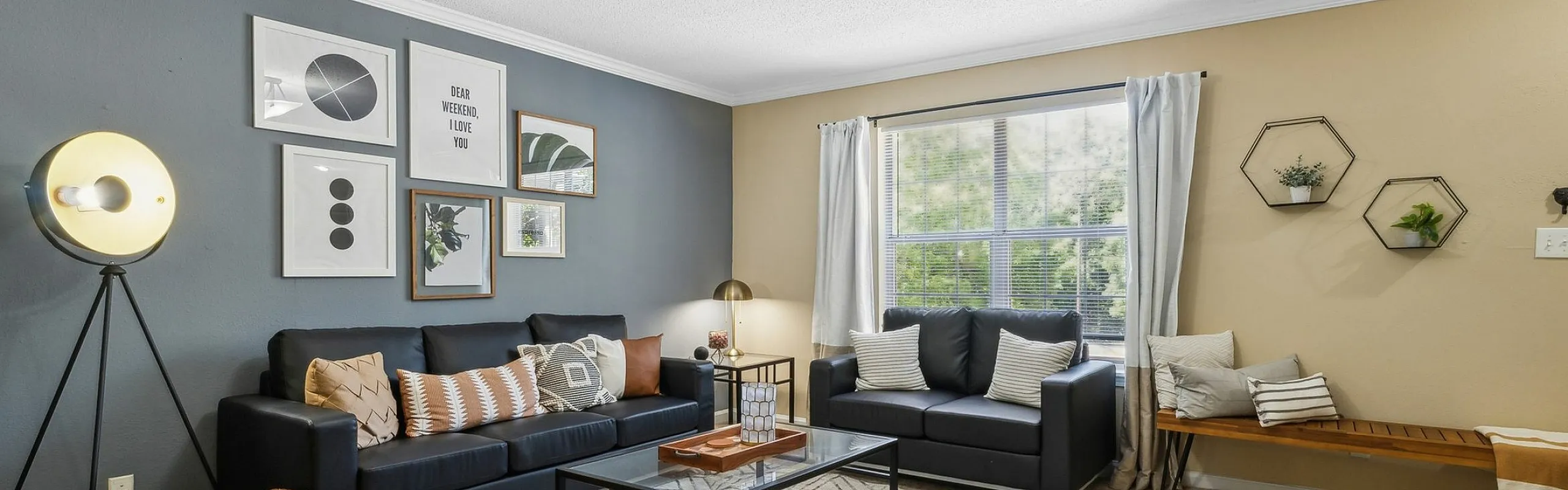 Inviting living room with modern decor, featuring a cozy sofa, stylish wall art, and large window for natural light.
