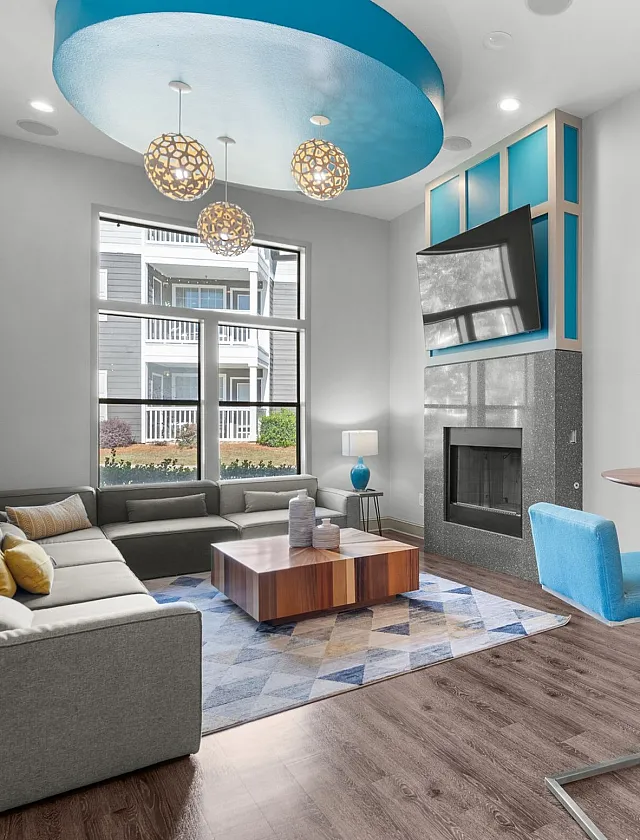 Bright modern living room with elegant decor, featuring a cozy sectional sofa, stylish pendant lights, and a vibrant wall art.