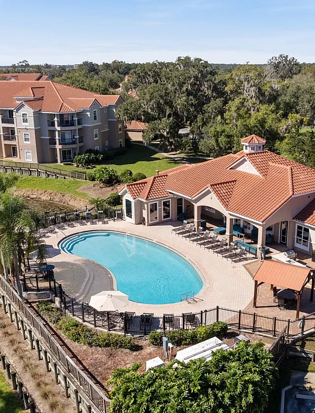 Luxury apartment community with stylish Mediterranean-style architecture, featuring a resort-style pool, beautifully landscaped gardens, and a tranquil canal view.