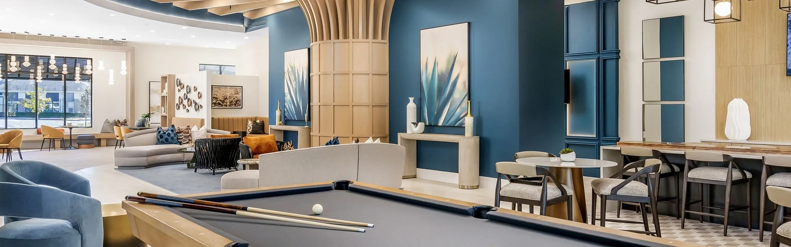 Contemporary luxury apartment lounge featuring a sleek pool table, stylish seating areas, and modern lighting accents.