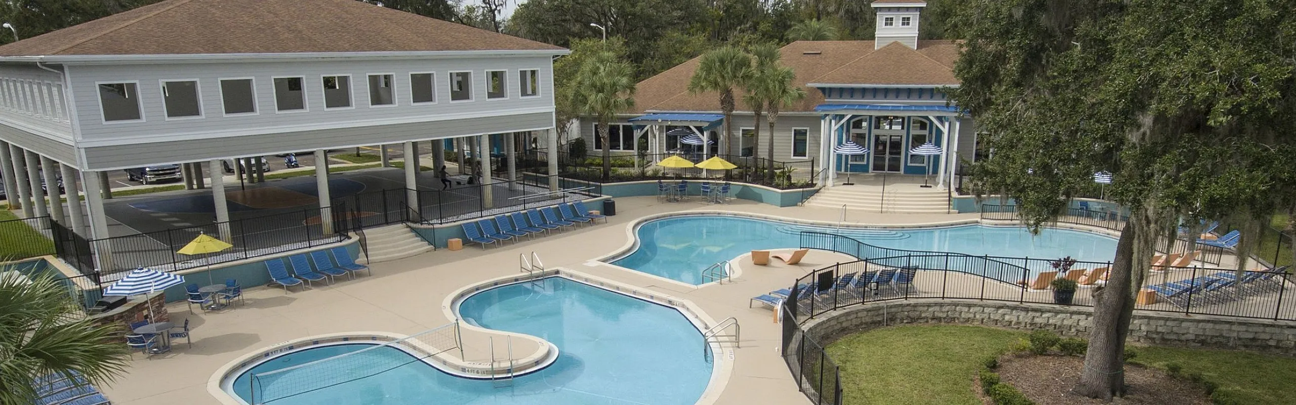 Inviting resort-style pool area with ample lounge chairs, shaded seating, and lush landscaping, perfect for relaxation and social gatherings.