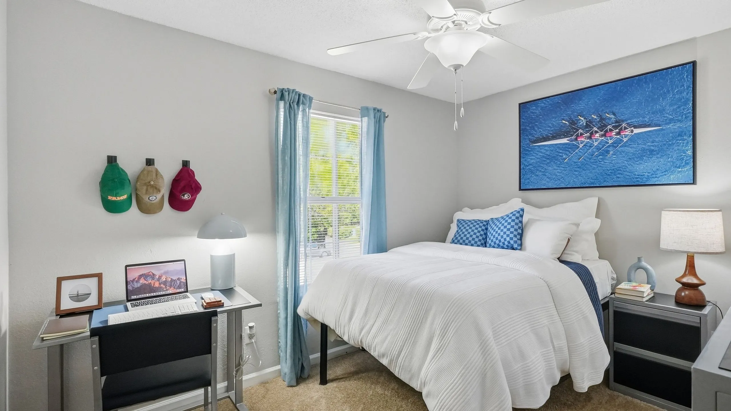 Bright and cozy bedroom with a comfortable bed, modern desk setup, and stylish decor, perfect for relaxation and productivity.