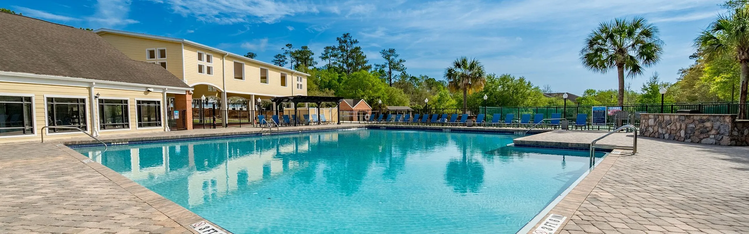 Inviting outdoor pool area with modern patio, surrounded by lush greenery and scenic views.