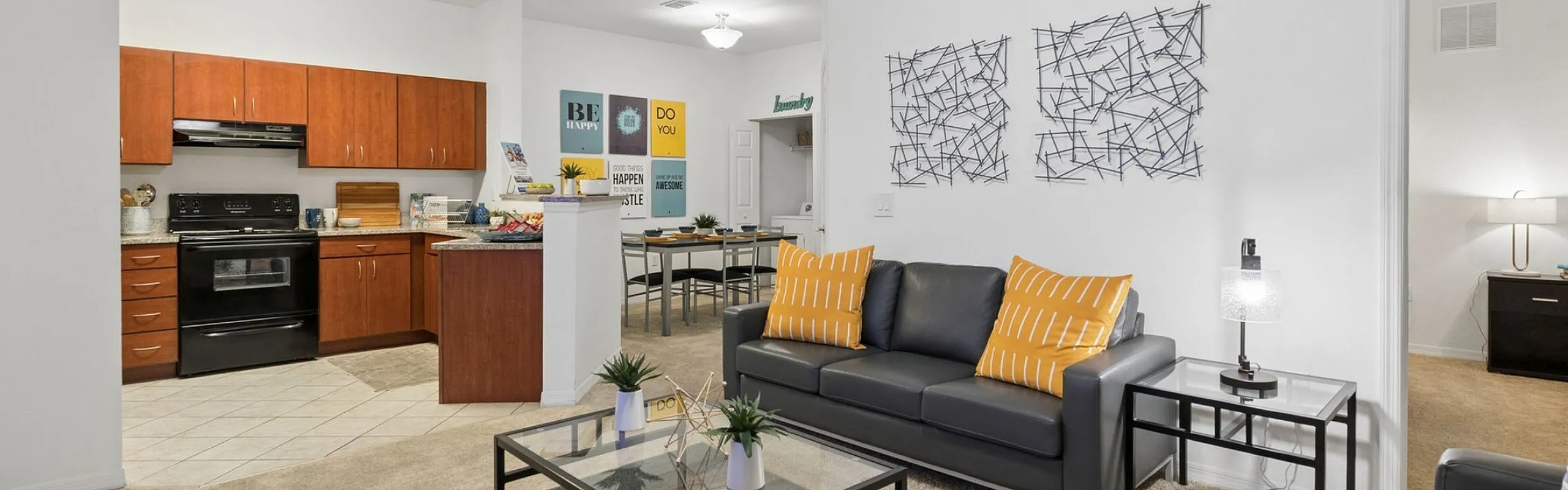 Chic open-concept living space featuring a cozy seating area with modern decor, adjacent to a spacious kitchen with wooden cabinetry and sleek appliances.