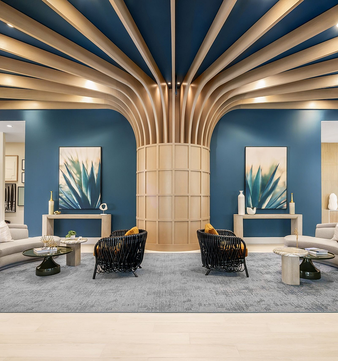Elegant lounge area with modern curved seating, vibrant artwork, and sophisticated d&eacute;cor under a striking ceiling design.