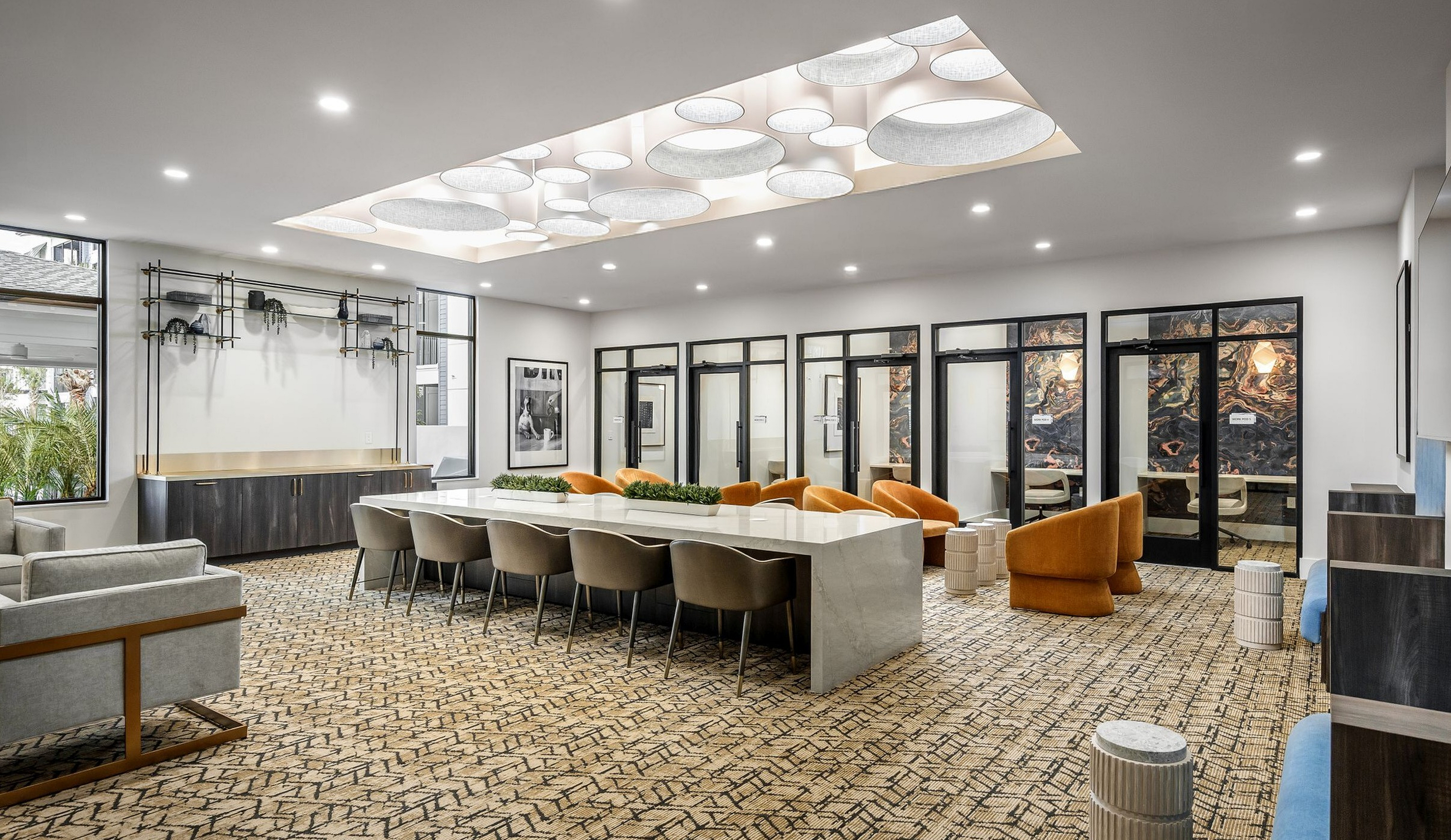 Luxurious communal space with modern lighting, elegant furnishings, and a sleek conference table, perfect for meetings and social gatherings.