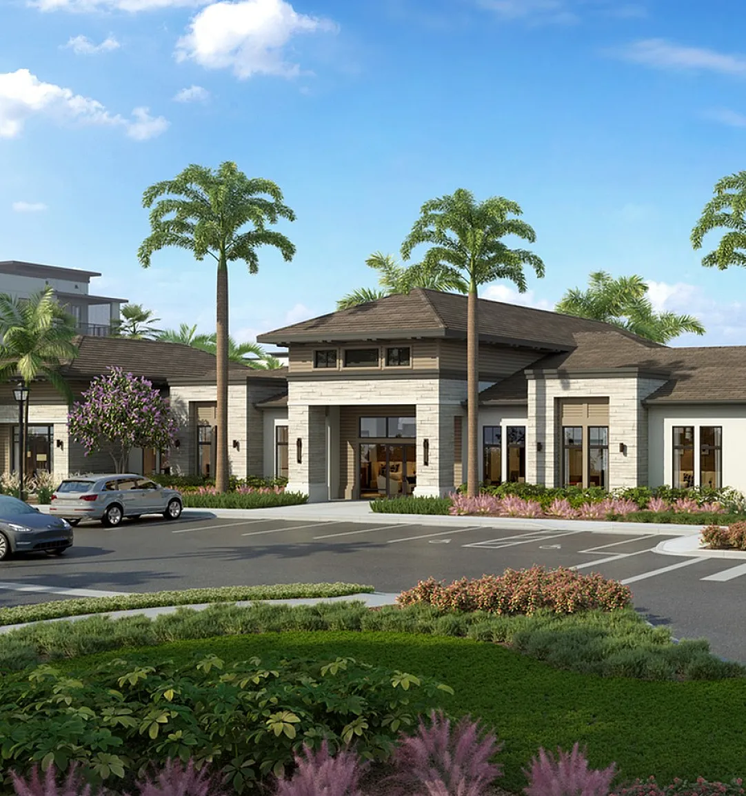 Elegant apartment complex entrance surrounded by lush greenery and tall palm trees under a clear blue sky.