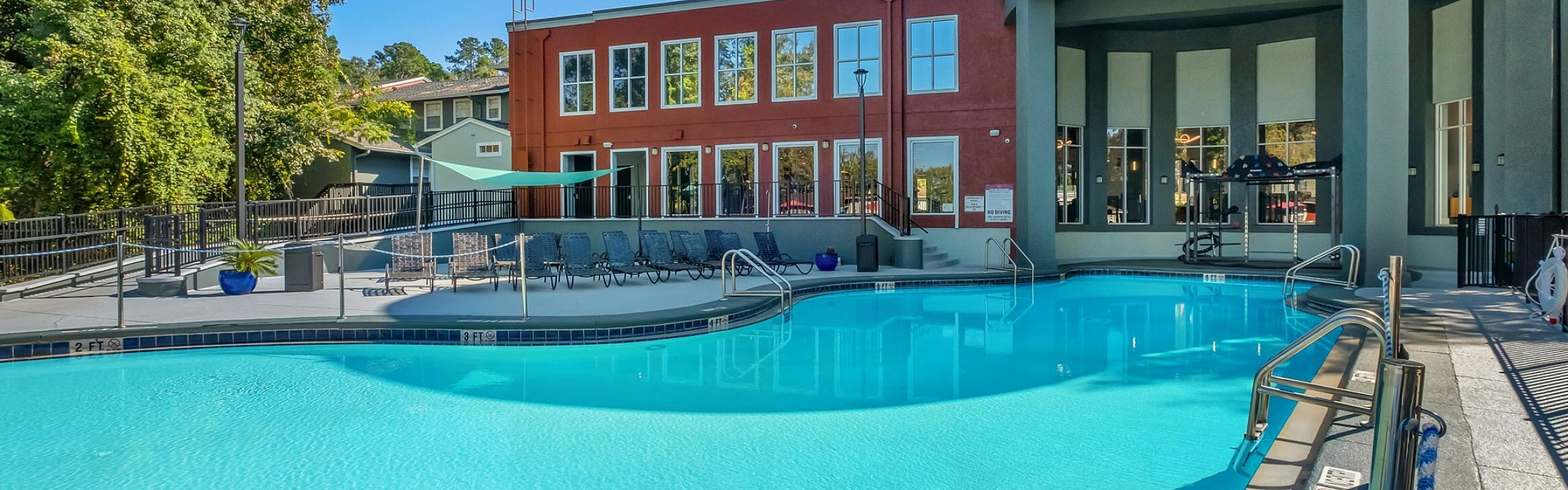 Inviting outdoor pool area with modern architecture and lush surroundings, perfect for relaxation and leisure.