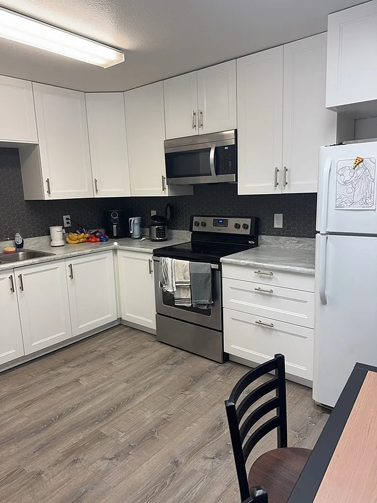 Modern kitchen with sleek cabinetry, stainless steel appliances, and stylish laminate flooring.