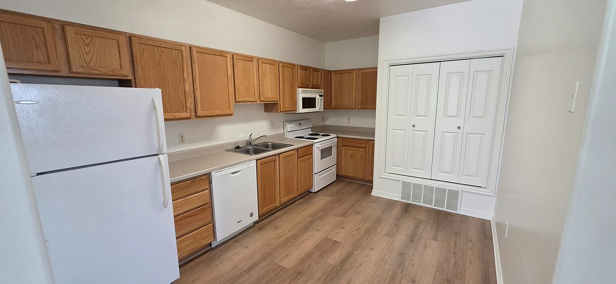 Inviting kitchen with elegant wooden cabinets, modern appliances, and sleek countertops perfect for culinary creativity.