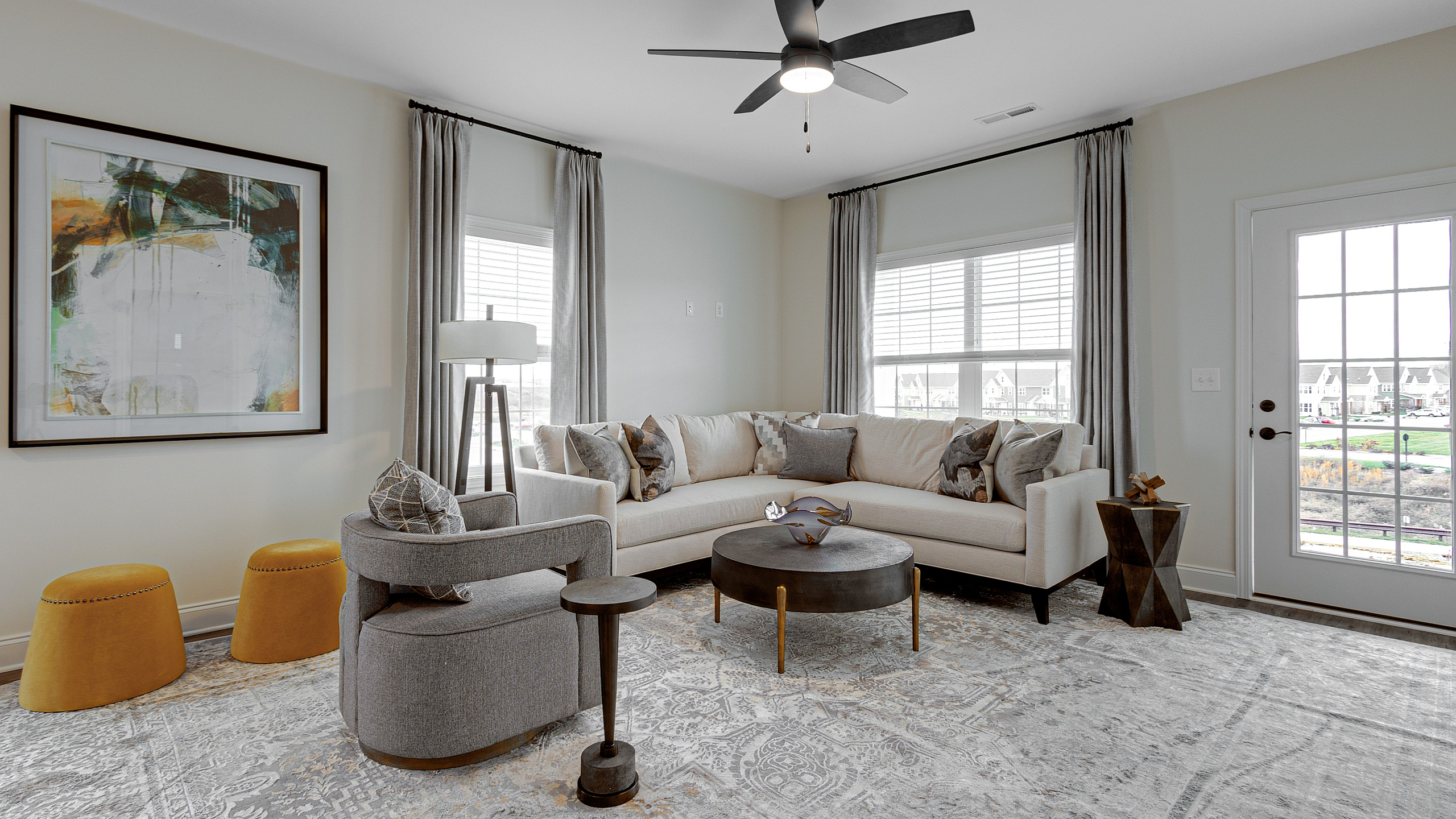 Bright and inviting living room with modern sectional sofa, elegant decor, and large windows offering scenic views.