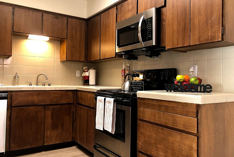 Cozy kitchen with warm wooden cabinetry, sleek stainless steel appliances, and inviting decor accents.