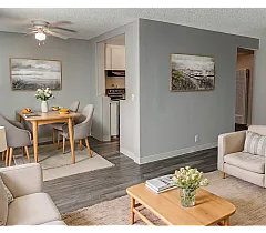 Contemporary living and dining area with elegant decor, featuring a cozy seating arrangement, stylish wooden furniture, and tasteful artwork.