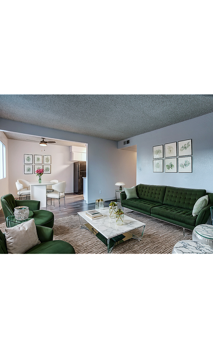 Contemporary living room with stylish green furniture, chic marble coffee table, and a nearby dining area featuring a modern white table and chairs.