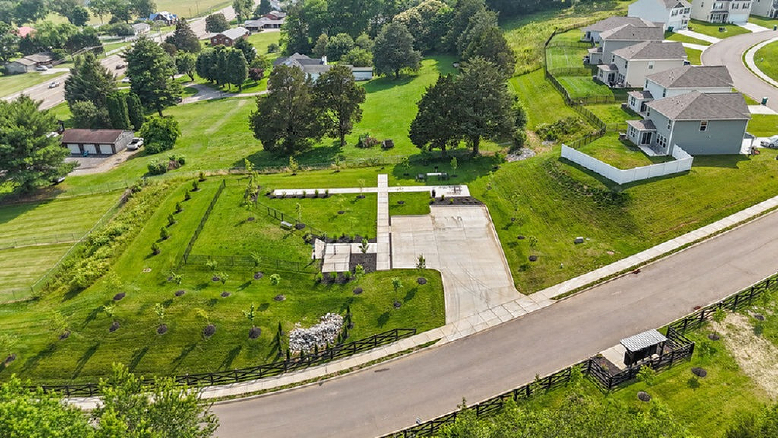 Aerial view of a picturesque residential area featuring lush greenery, modern houses, and a well-maintained street in a serene neighborhood.
