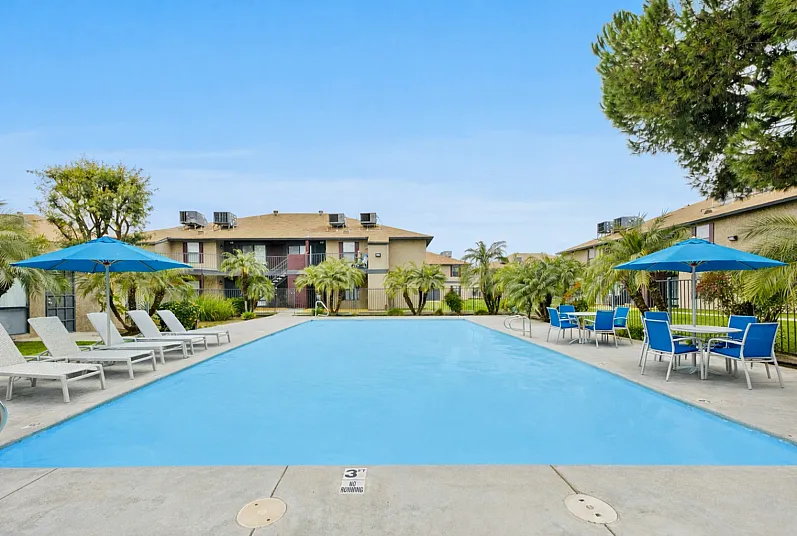 Sparkling pool, with lush landscaped apartment surroundings in Bakersfield affordable housing community