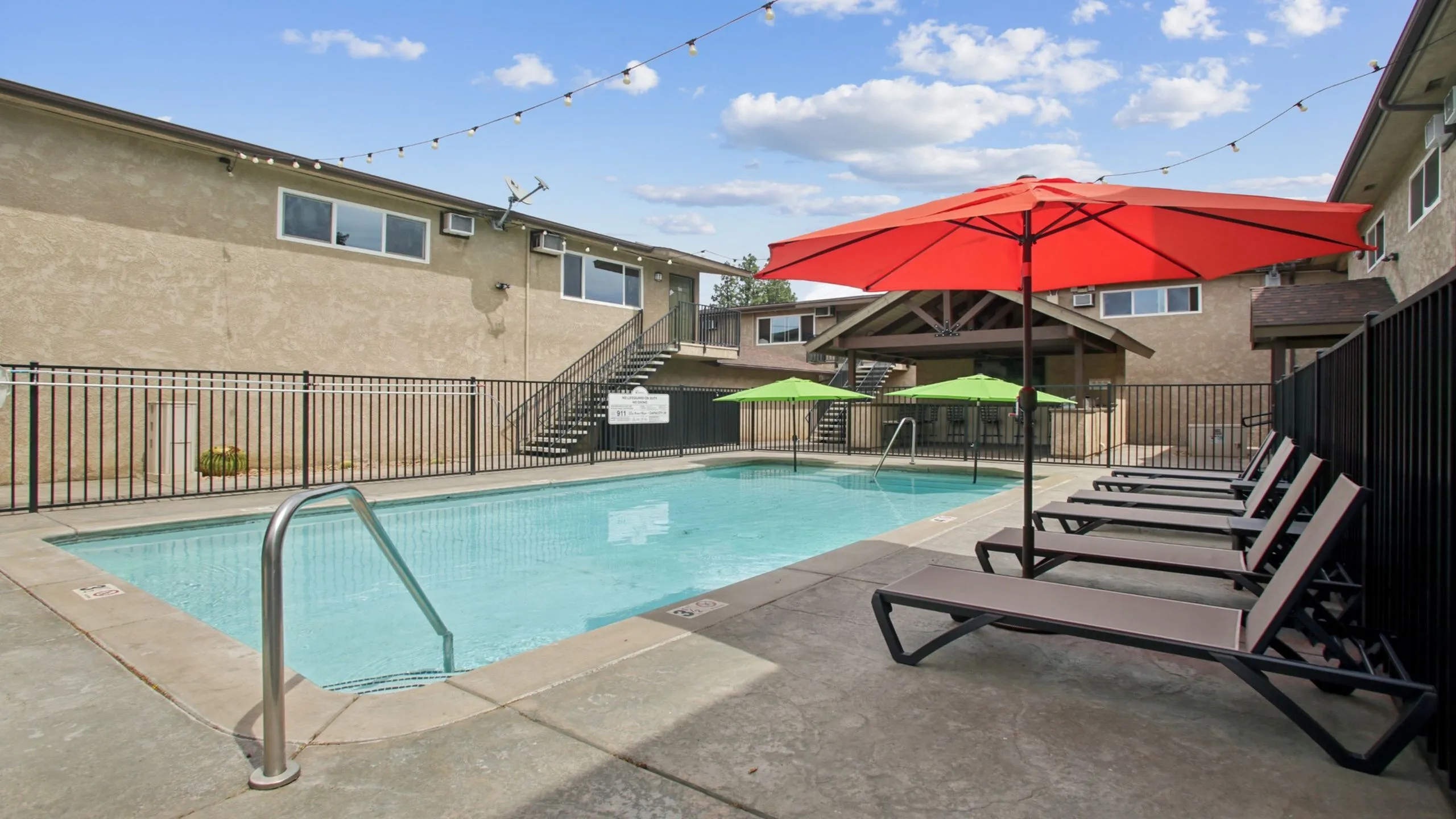 Inviting outdoor pool with vibrant umbrellas and comfortable lounge chairs, ideal for relaxation and leisure.