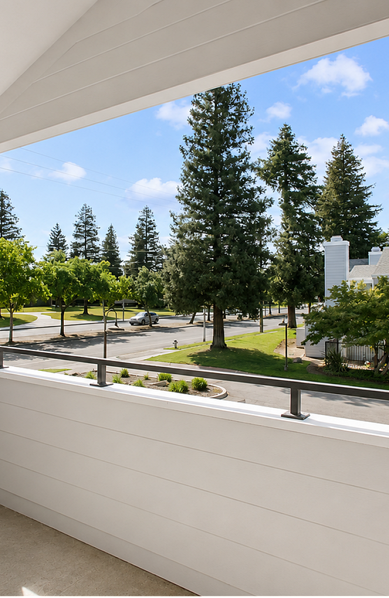 Charming balcony view showcasing a tranquil, tree-lined street with modern architecture and lush greenery.