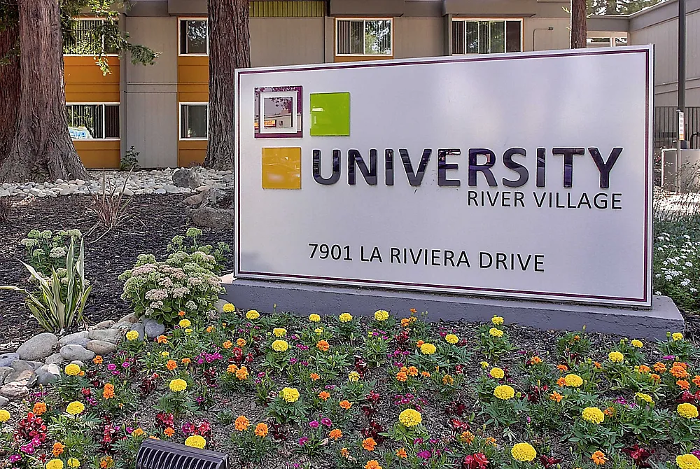 Beautiful garden view of University River Village with vibrant flowers and modern architecture at 7901 La Riviera Drive.