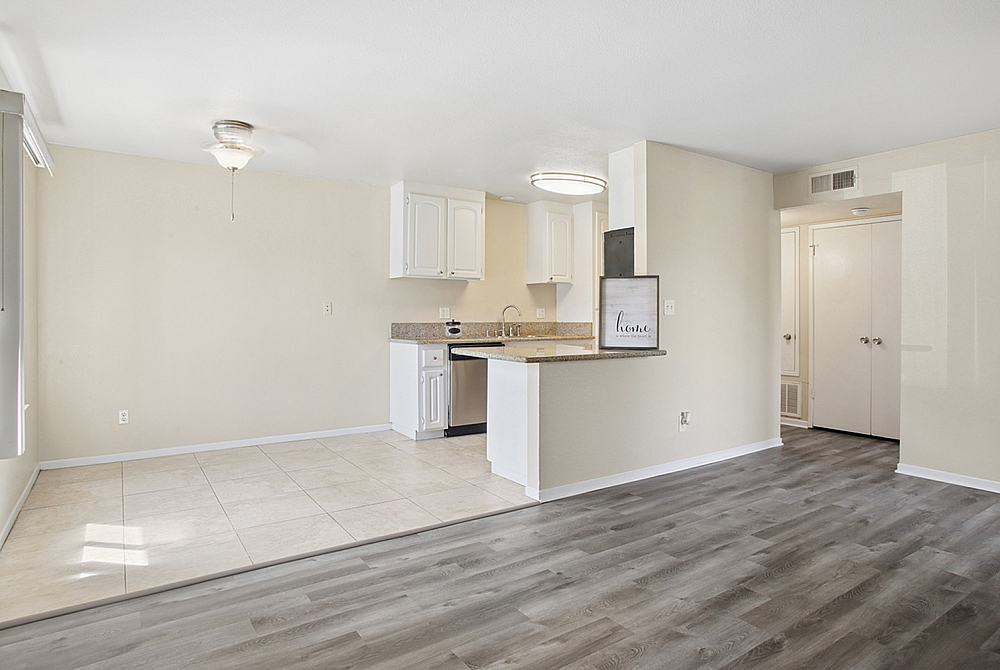 Bright and modern open-concept kitchen with sleek countertops, light beige walls, and chic flooring, ideal for stylish living.
