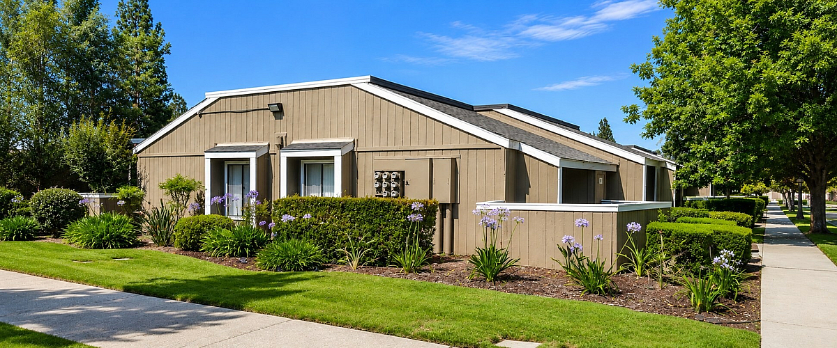 Charming single-story apartment surrounded by lush greenery and vibrant flowers, offering a serene suburban lifestyle.