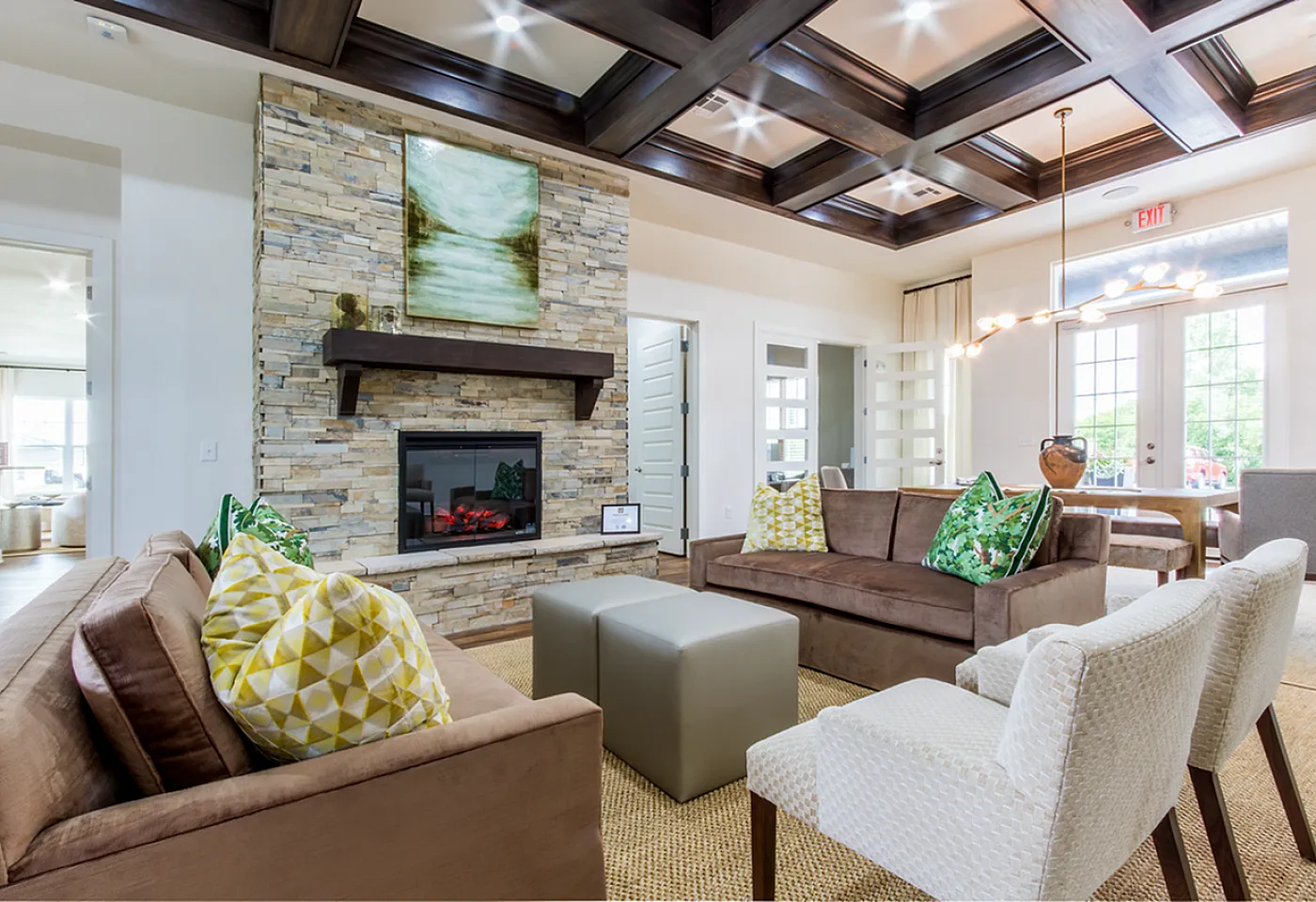 Luxurious open-concept living room featuring a cozy stone fireplace, stylish seating, and modern lighting.