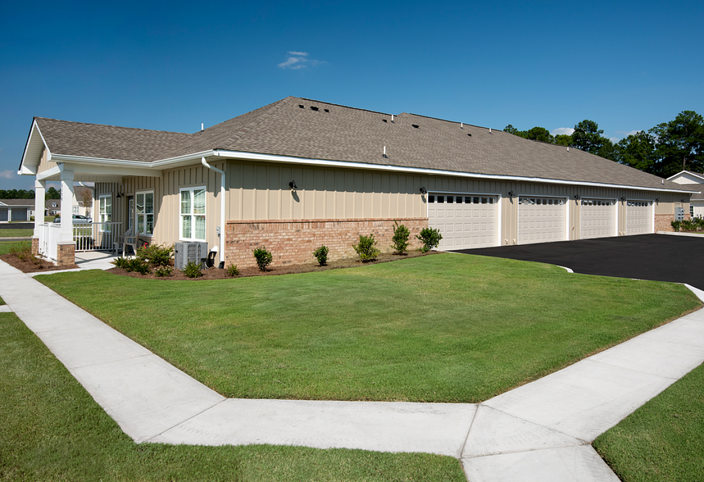 Charming duplex with beautiful landscaping, stylish porch, and modern garages set in a peaceful neighborhood.