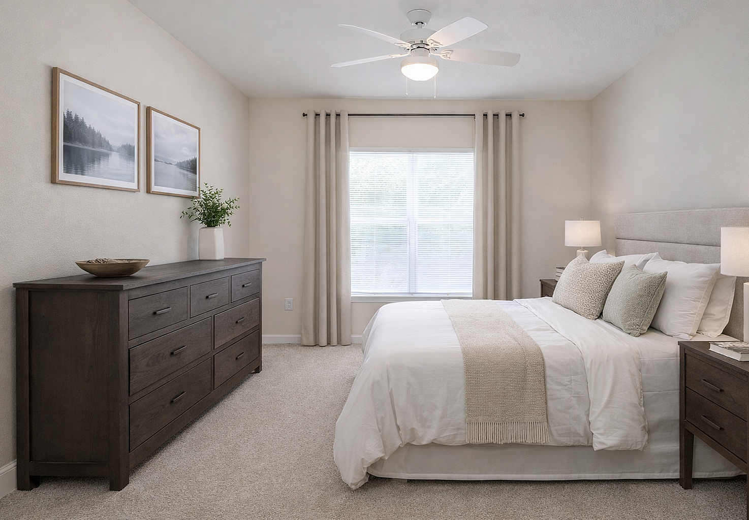 Inviting bedroom with a plush bed, soft lighting, and elegant decor; features large windows with natural light and stylish furnishings.