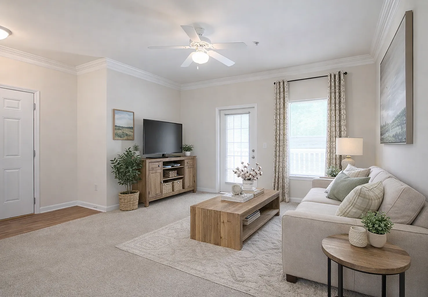 Inviting living room with plush beige sofa, elegant wooden furniture, and abundant natural light through large windows.
