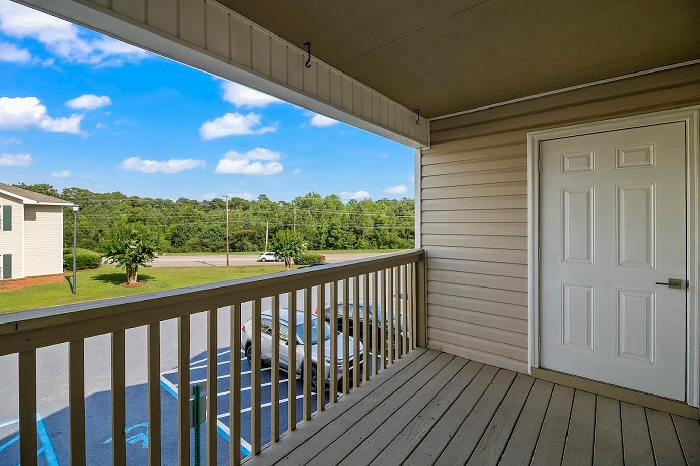 Elevated balcony with picturesque views of a lush green landscape and bright blue sky.