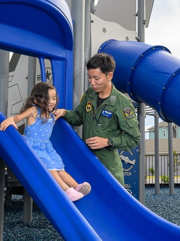 child playing on slide with father
