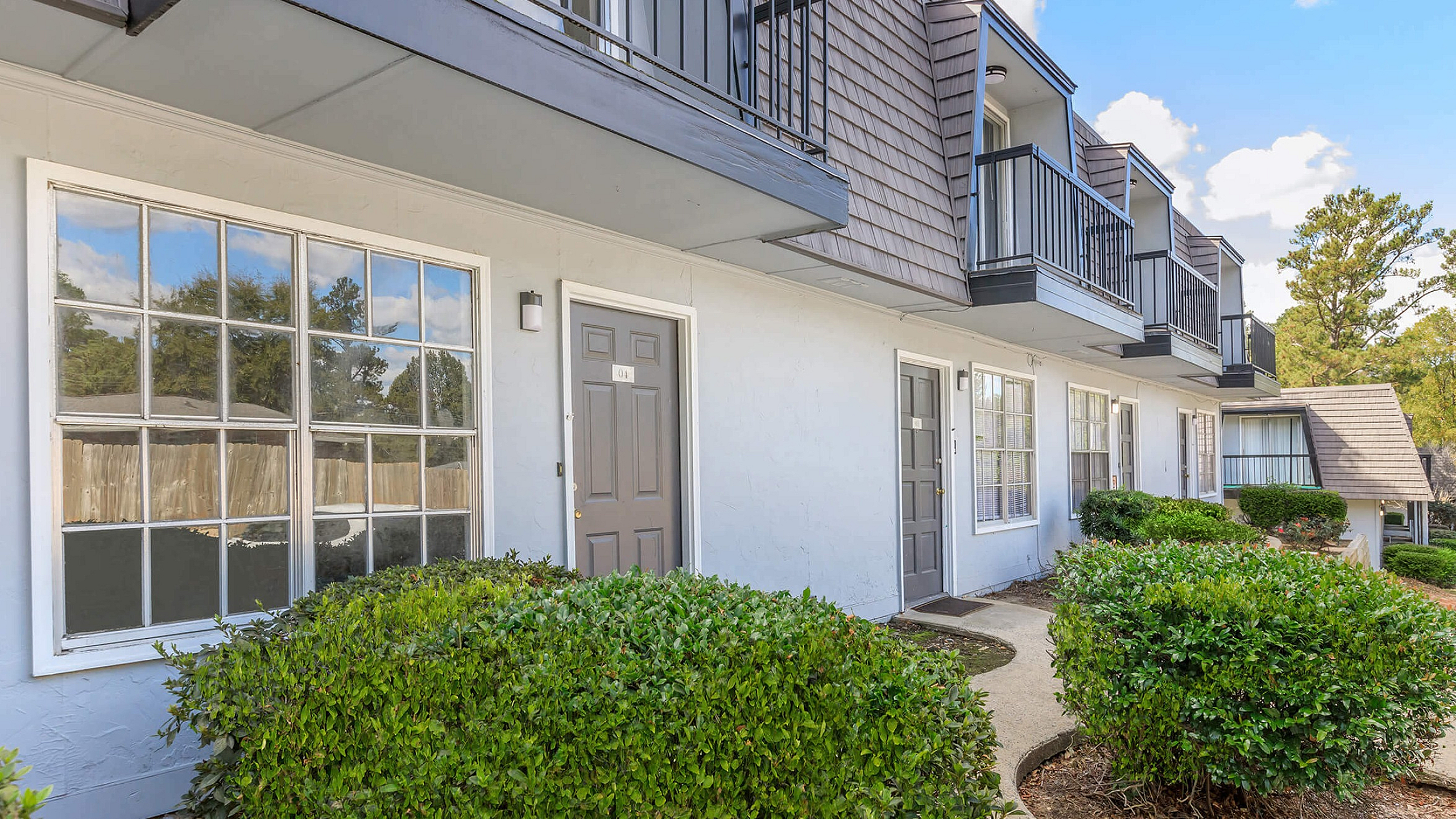 Inviting apartment exterior with well-maintained gardens and balconies.