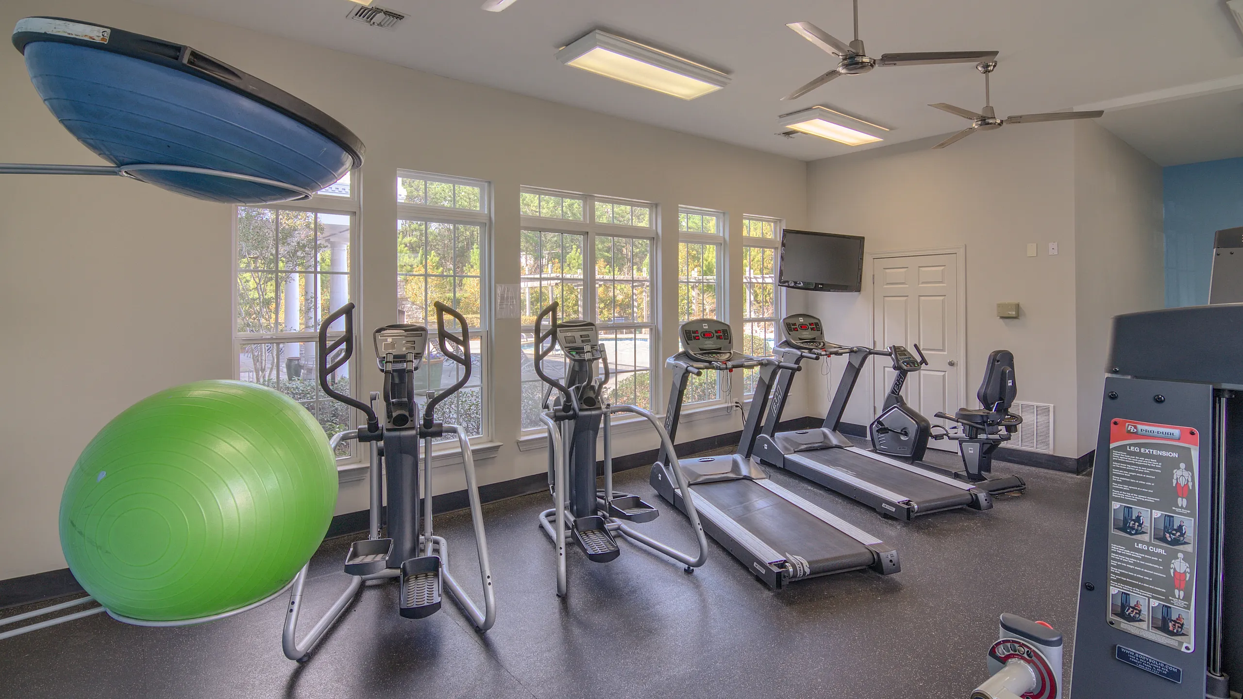 Bright and inviting fitness center featuring treadmills, elliptical machines, and exercise equipment.