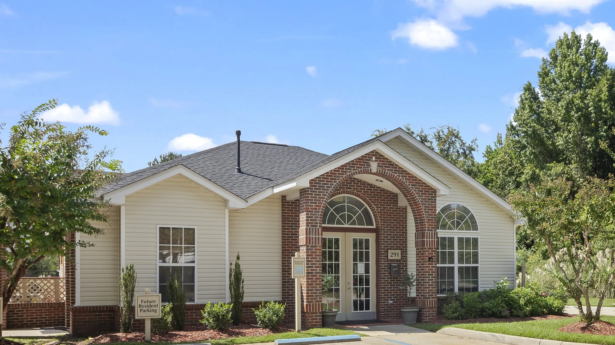 Inviting clubhouse exterior with classic brick facade and landscaped surroundings.